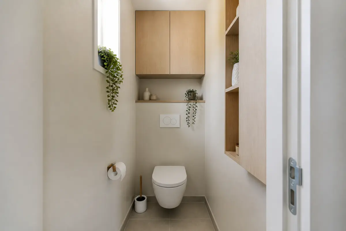 Petite toilette moderne avec plantes vertes en décoration pour les toilettes élégantes et fonctionnelles